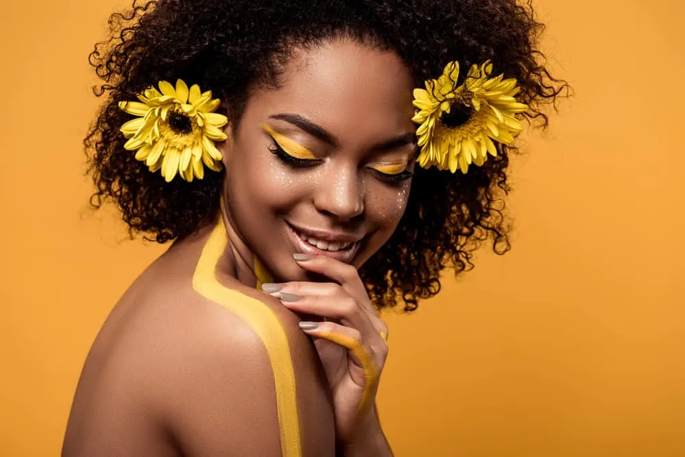 gorgeous black girl with yellow flowers in her hair posing for 4444 angel number photo