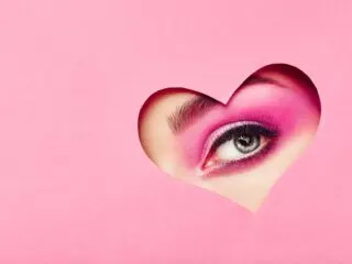 cutout of woman's eyes on a pink heart construction paper 606 angel number meaning