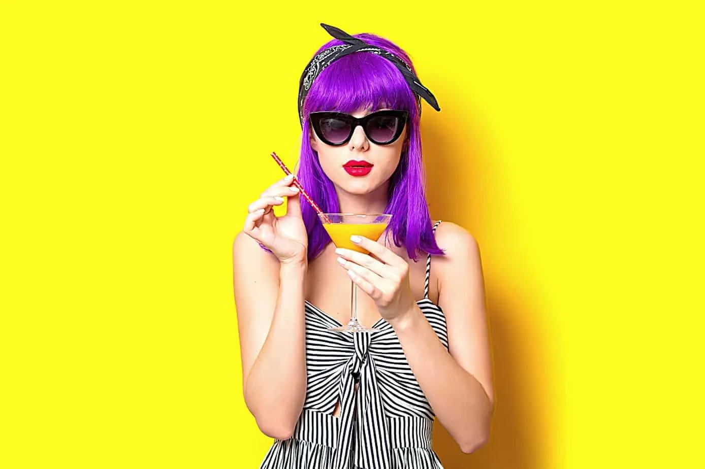cute trendy hipster woman in purple wig and big glasses sipping an orange martini angel numbers good luck