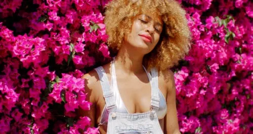 black woman on roses in a manifesting ritual for self love