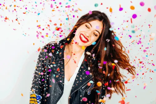 beautiful woman excited about manifested money coming and glitter raining down on her