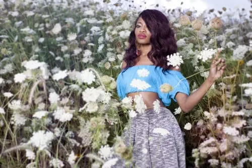 black woman in a field of roses posing like a model